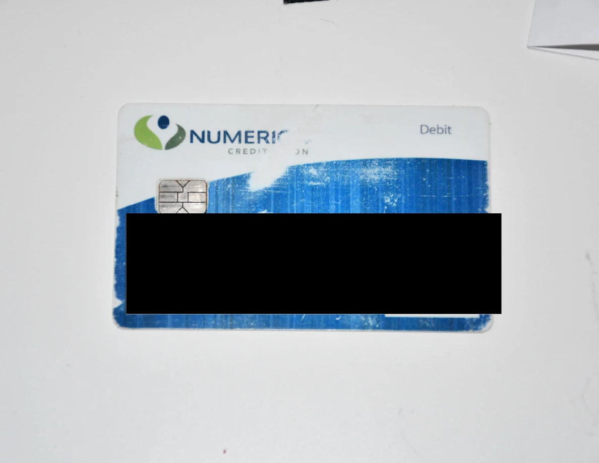 Bank card with identifying information obscured by a black redaction.