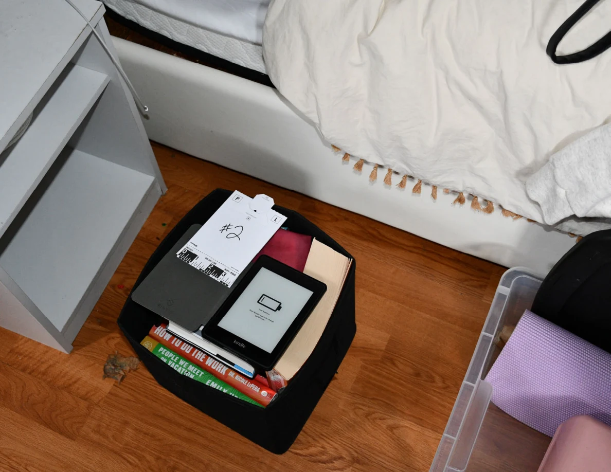 Number 2 scale card beside an e-reader and books inside a black fabric bin.