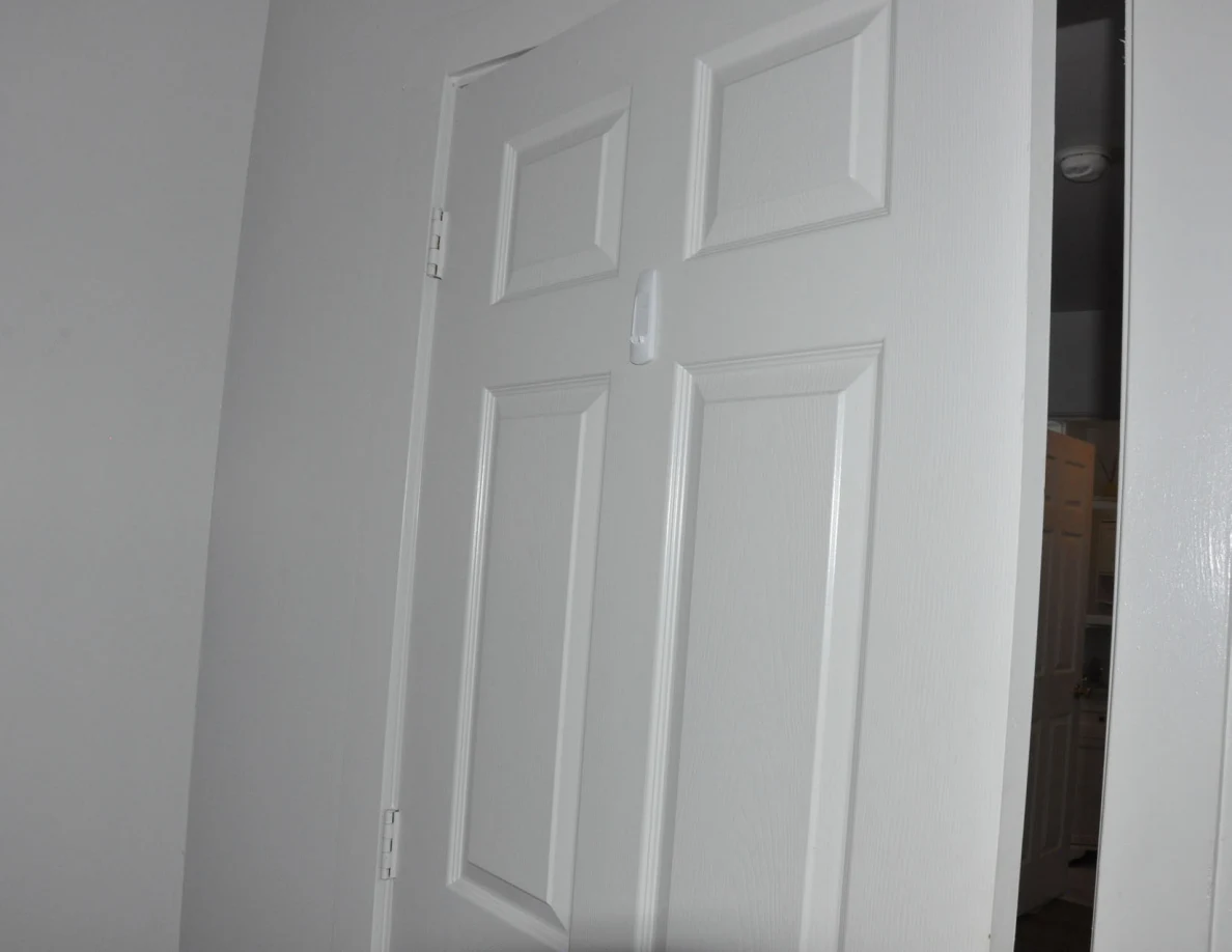 Upper white paneled door with a small hanging white tag.