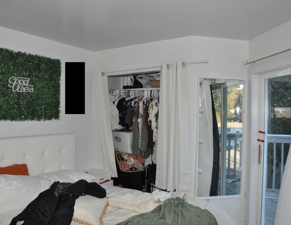 Bed beneath a Good Vibes greenery panel beside an open clothes closet and balcony door.