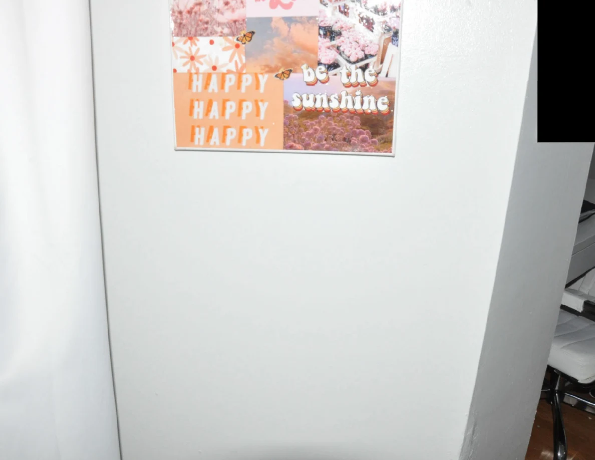 Colorful wall collage featuring flowers and positive phrases beside a curtain.