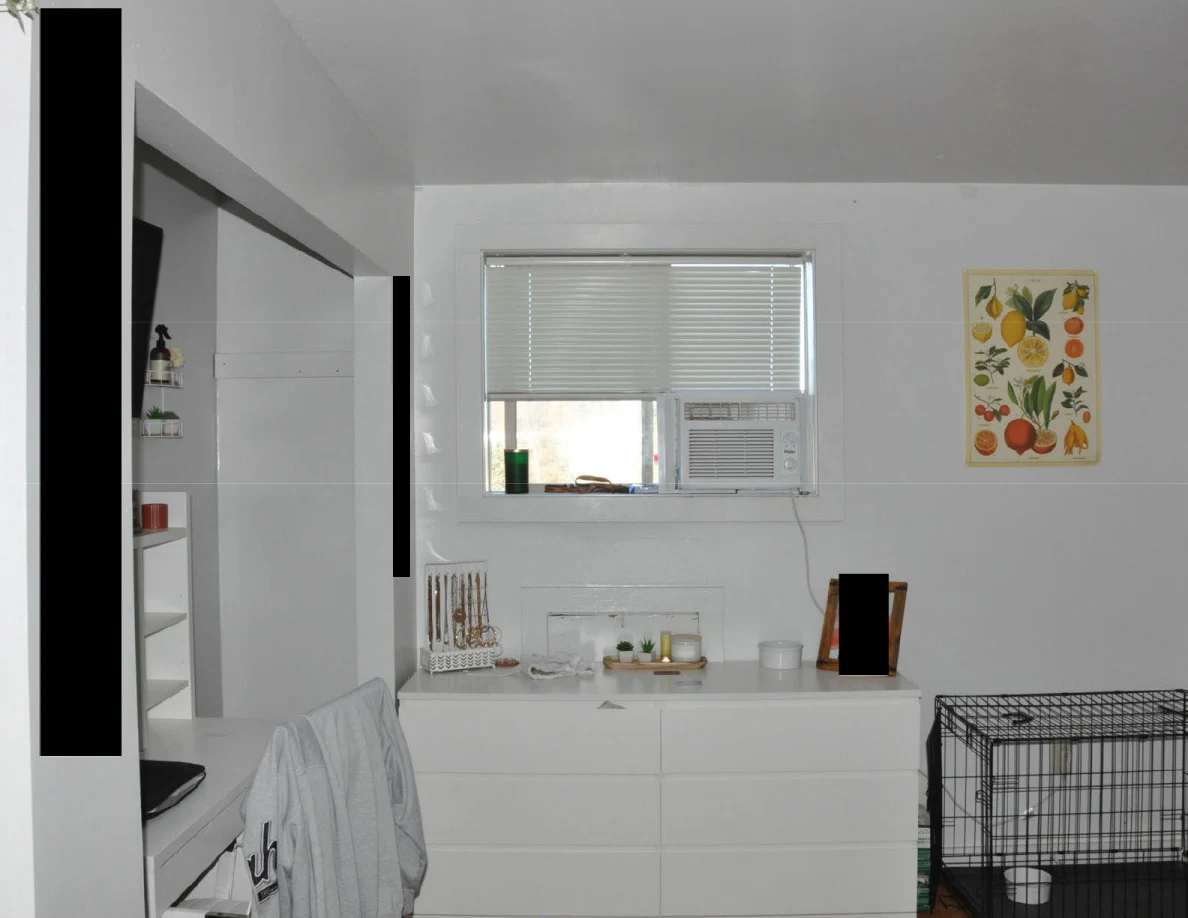 Bedroom window with air conditioner above a dresser beside fruit artwork.