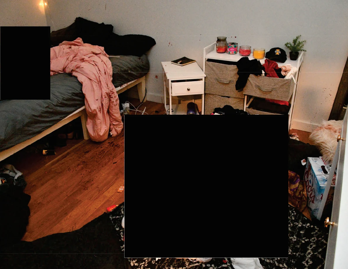 Bed with gray sheet and pink blanket beside white furniture and a tall mirror, with a large redaction in the foreground.