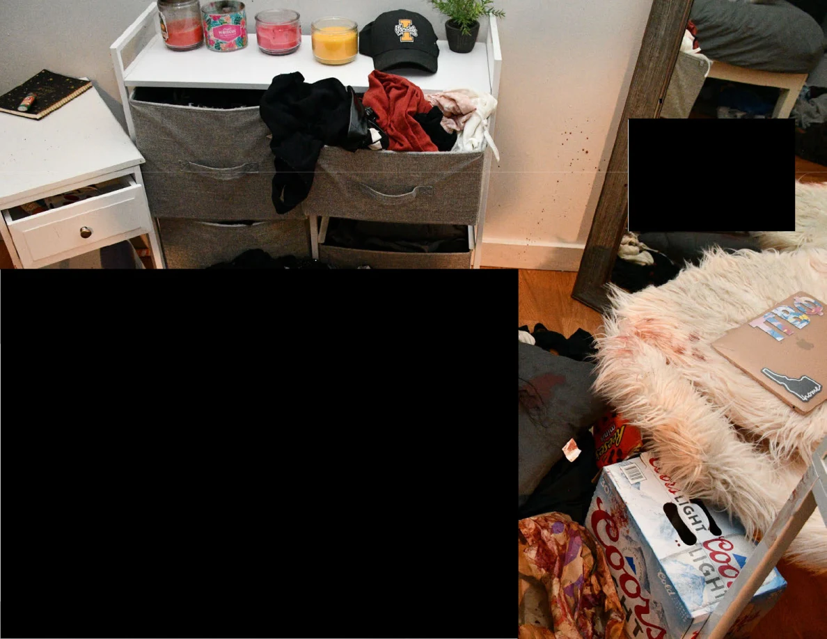 White bedside furniture, candles and mirror beside a fluffy chair and large redacted foreground.