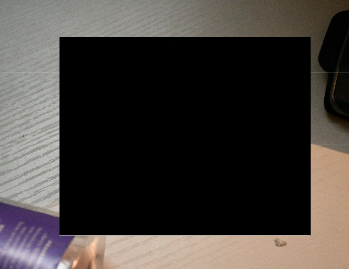 Close view of a white tabletop largely obscured by a black redaction.