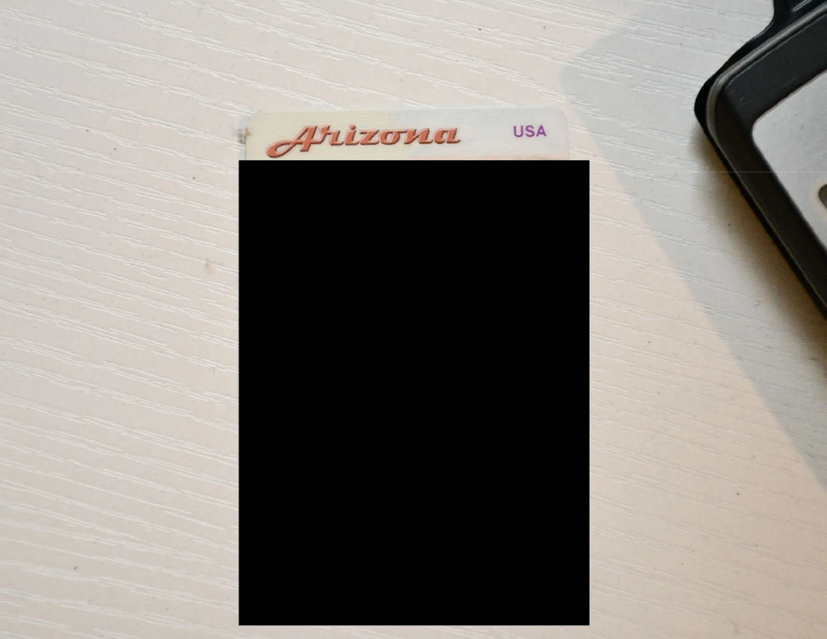 Close view of an Arizona identification card with personal details blacked out.