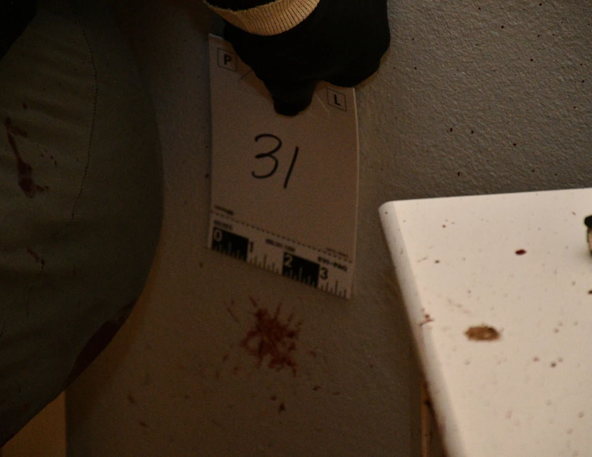 Scale card 31 beside a reddish wall mark near a bed and cabinet.