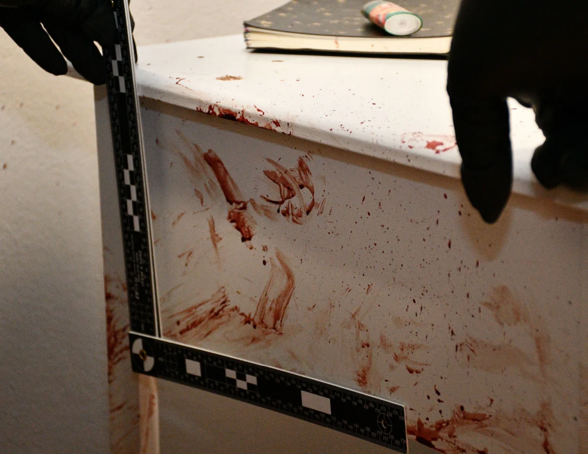 Black measuring scale around reddish cabinet smears with a notebook on top.