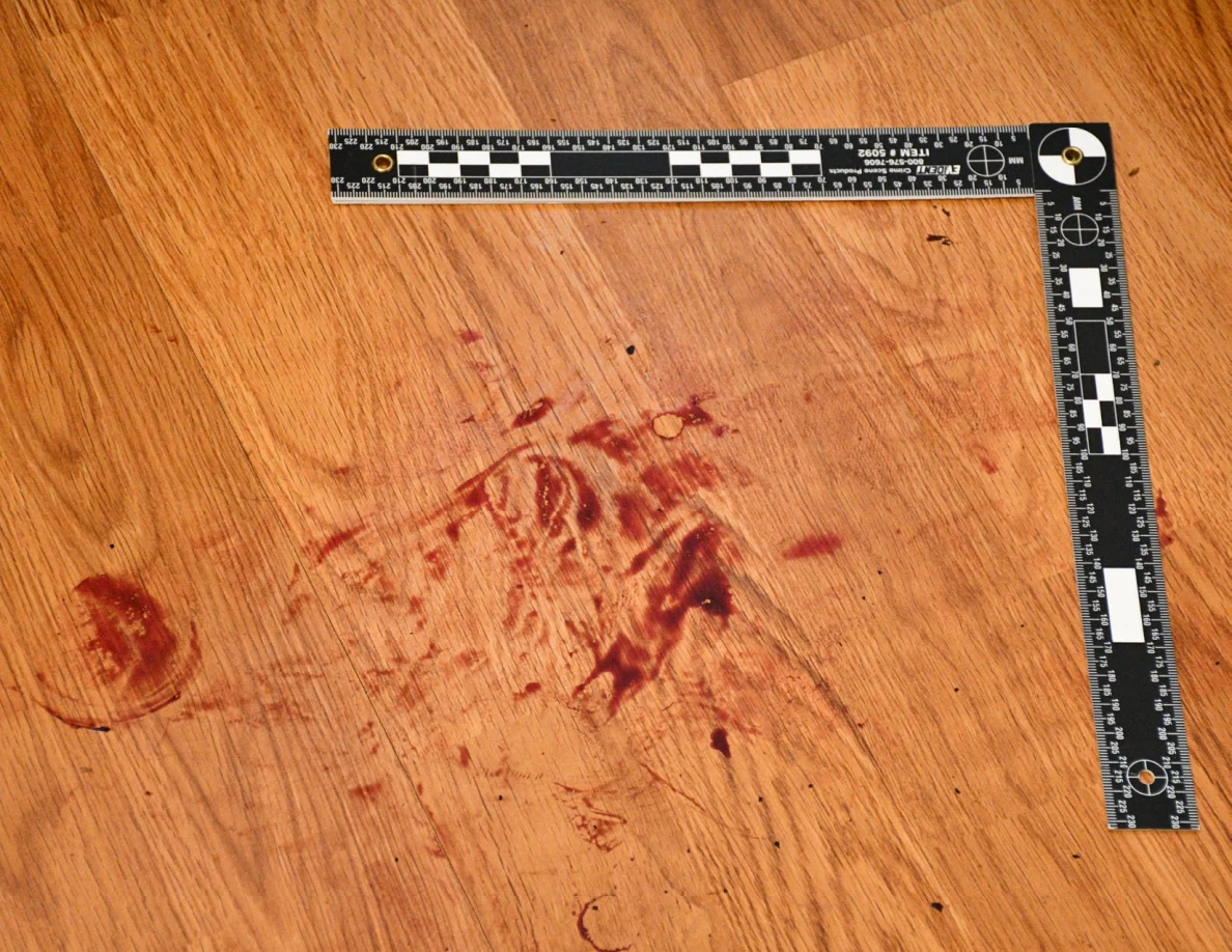 L-shaped measuring scale around reddish floor marks.