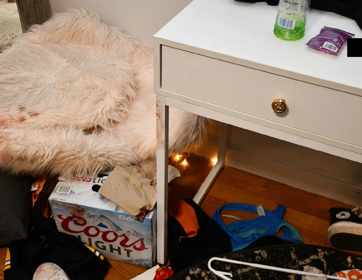 Fluffy pale chair beside a white desk with toiletries above and a drink carton below.
