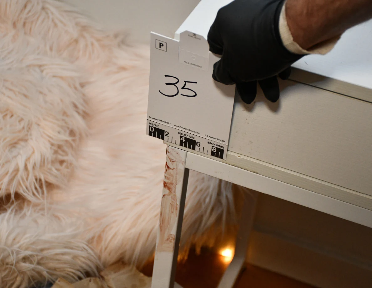 Scale card 35 beside reddish marks on a white desk leg.