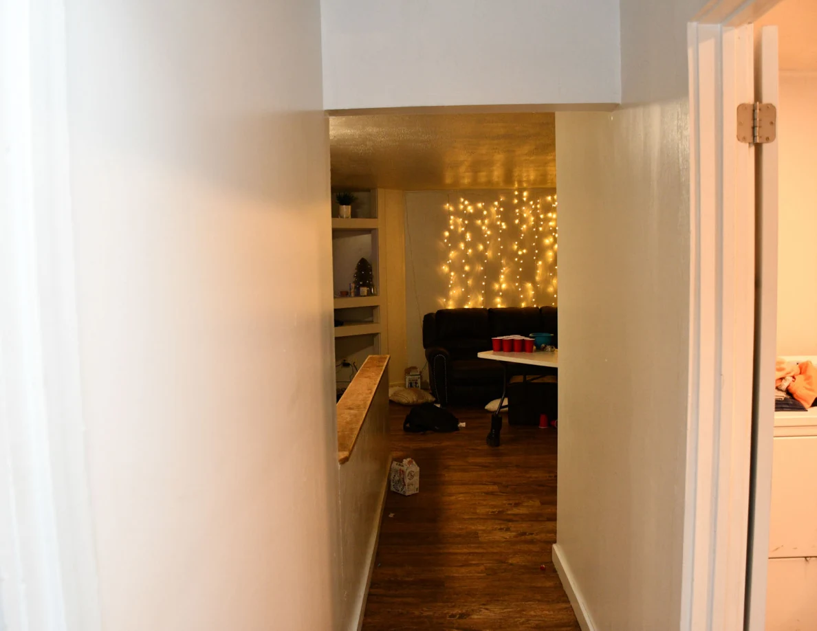 Hallway looking toward a couch, red cups on a table and a wall of string lights.