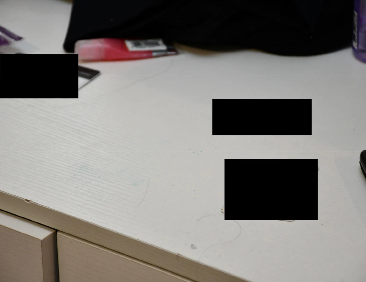 Close view of a white desktop with several blacked-out areas.