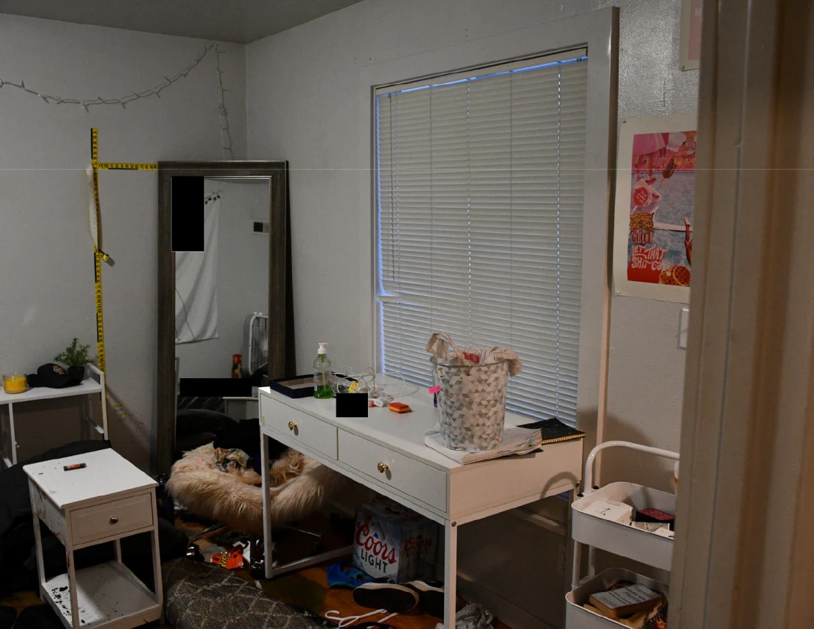 Bedroom desk, basket and tall mirror beside closed blinds and yellow wall scales.