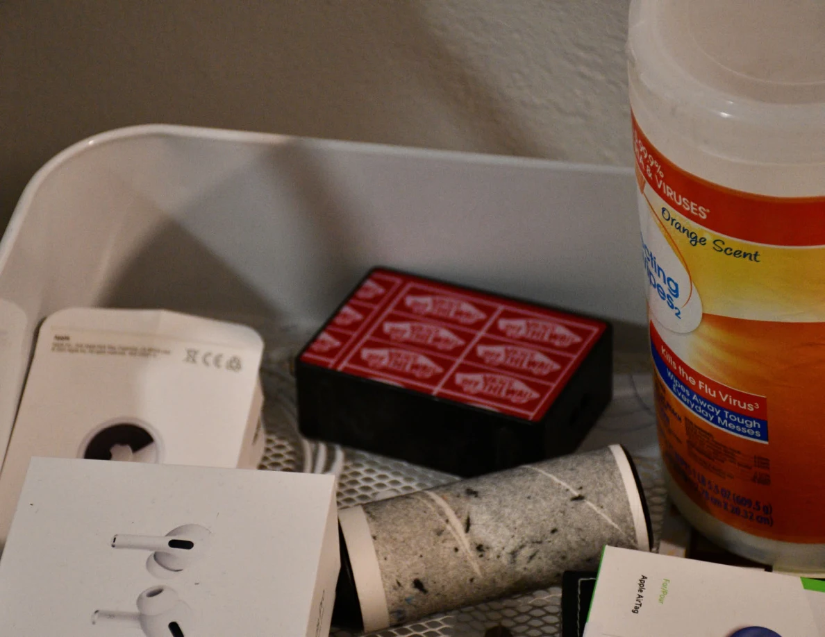 Close view of wipes, small boxes and lint rollers in a white storage cart.