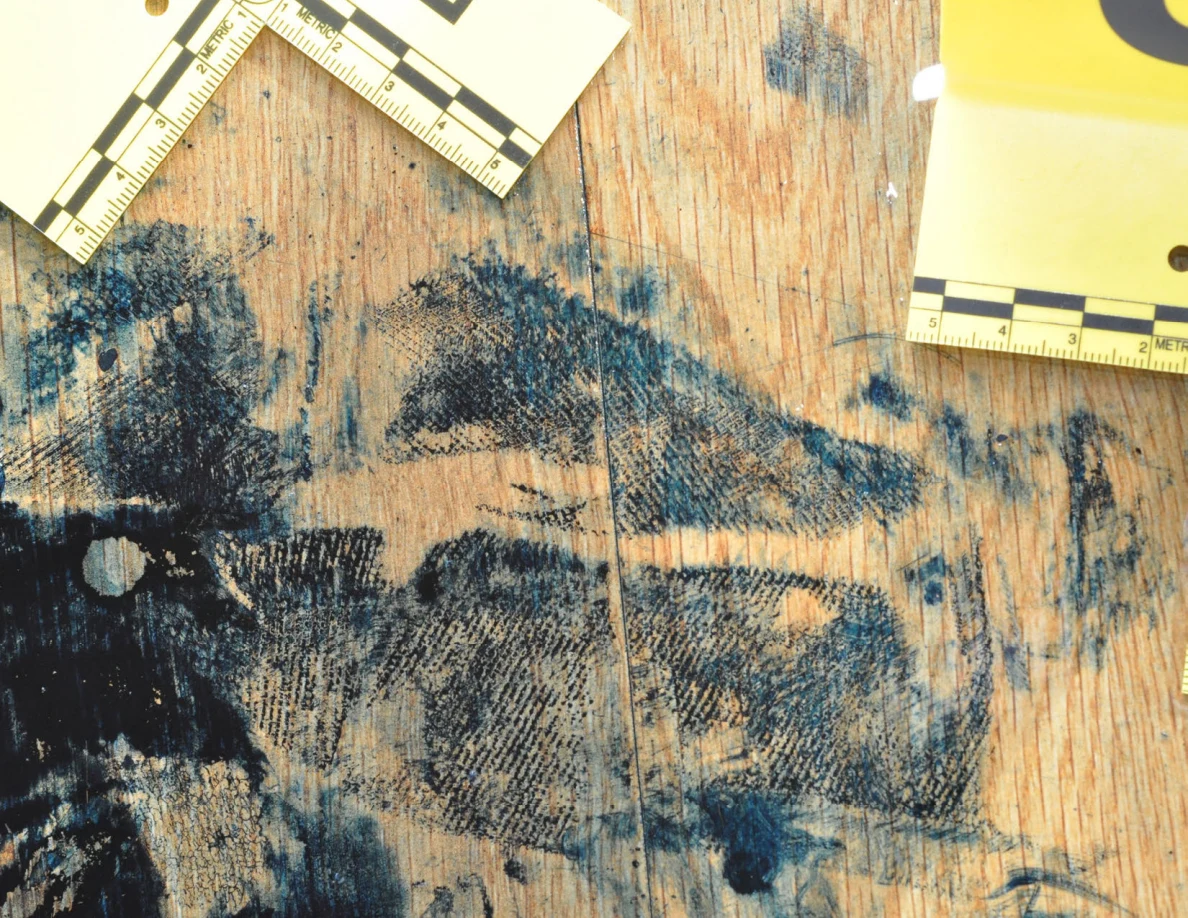 Close view of dark patterned floor marks between measuring cards.