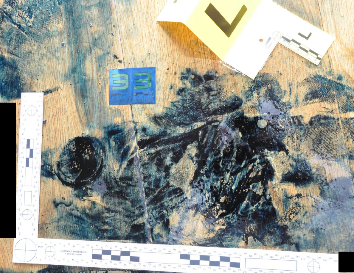 Dark patterned floor marks within an L-shaped measuring scale beside blue and yellow cards.