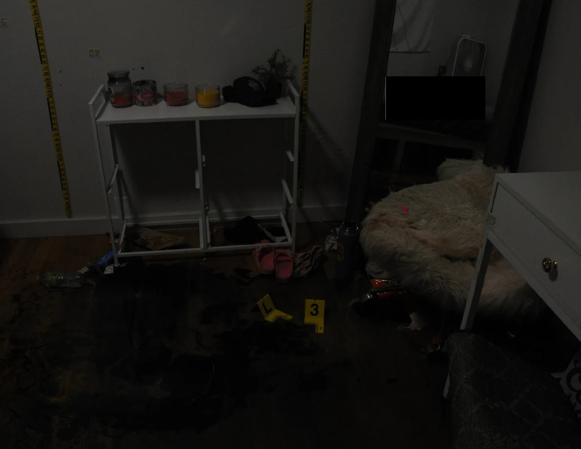 Dim bedroom view with white cabinet frame and yellow markers on a darkened floor.