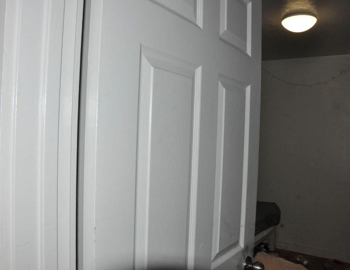 White paneled door with the bedroom ceiling light visible beyond.