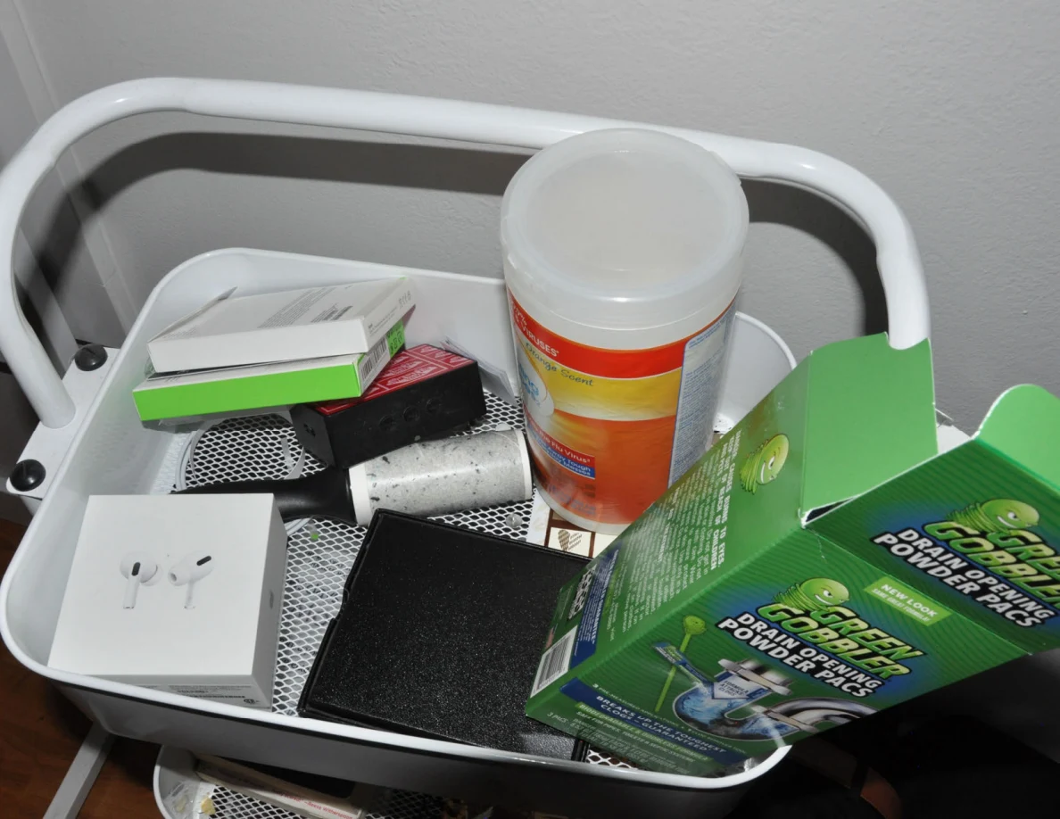 Wipes, drain-cleaning packets, earbud packaging and small boxes in the top cart tray.