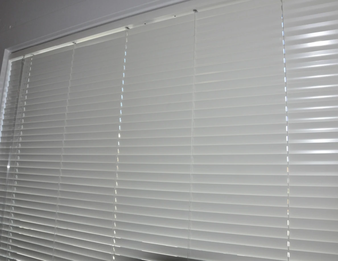 Close view of closed white window blinds.
