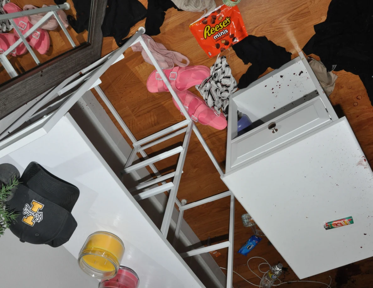 Overhead view of white furniture frames beside candles, a cap, pink slides and clothing.