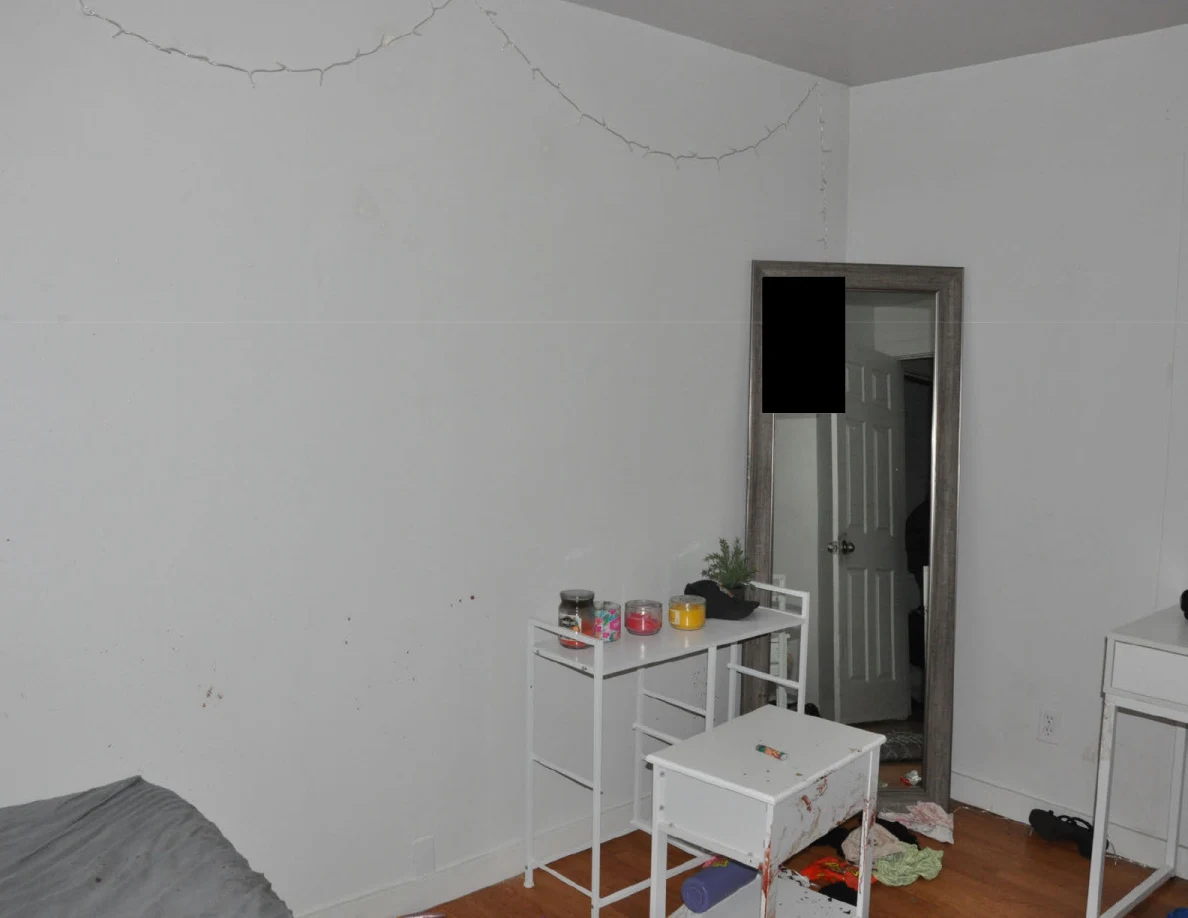 White wall with string lights above a mirror and white cabinet.
