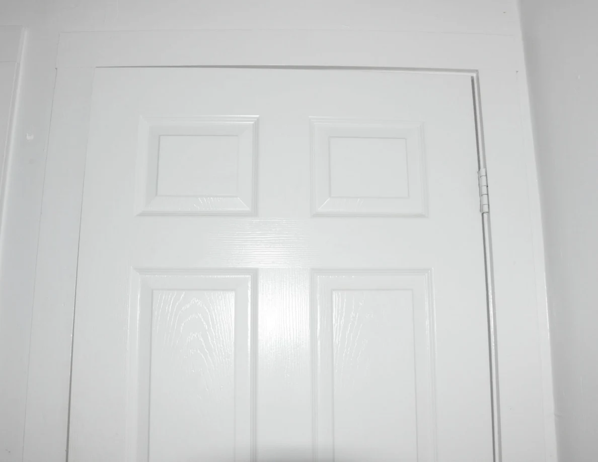 Upper panels and frame of a closed white door.