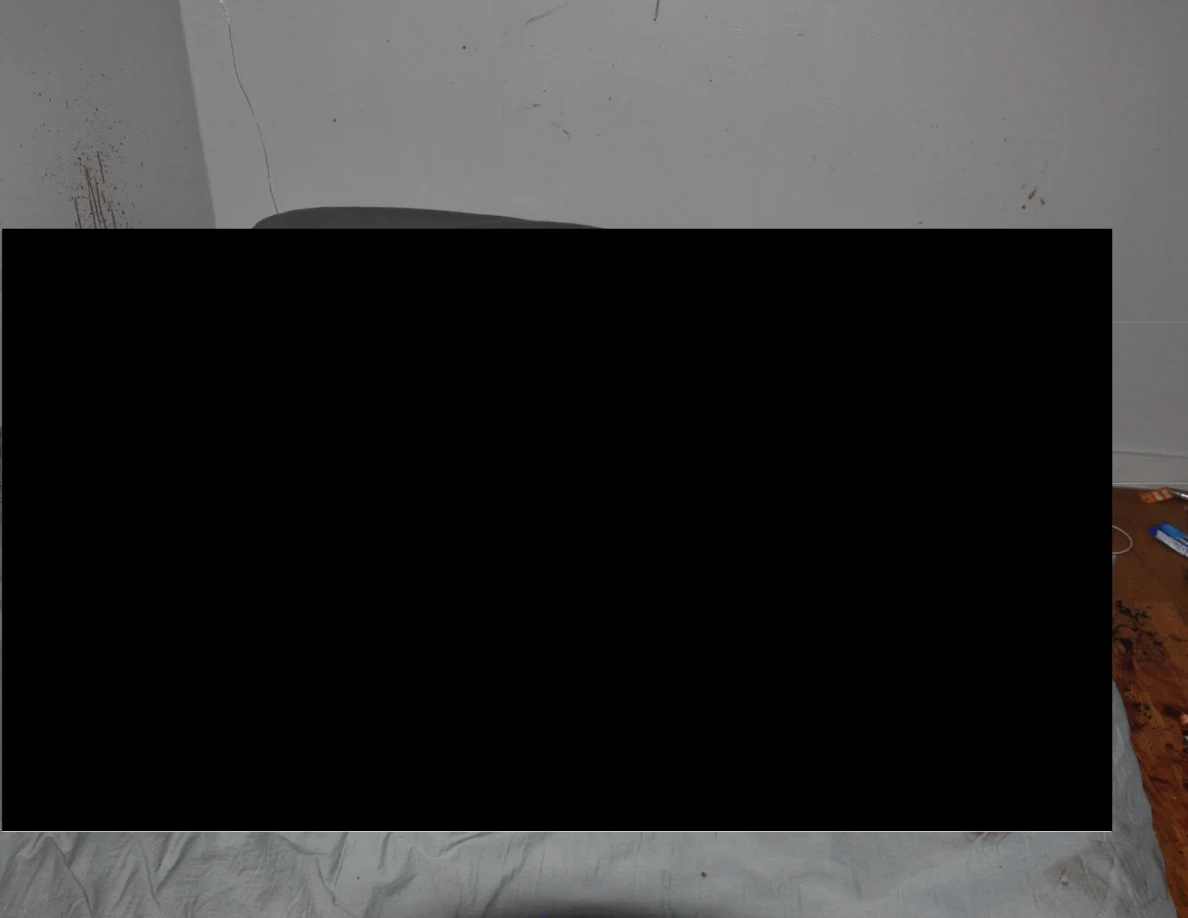 Close view of a bed largely obscured by a black redaction.