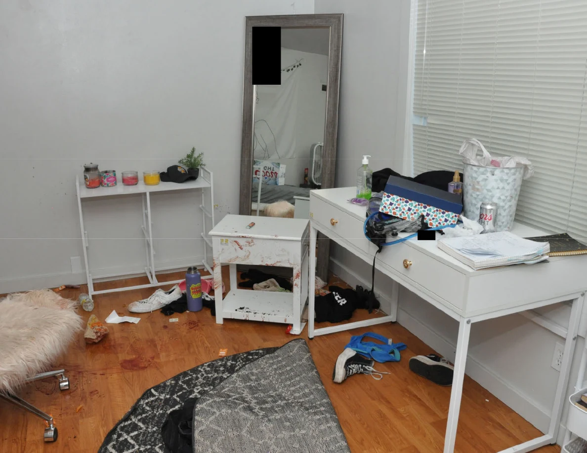 Bedroom desk and mirror beside a white cabinet and folded patterned rug.