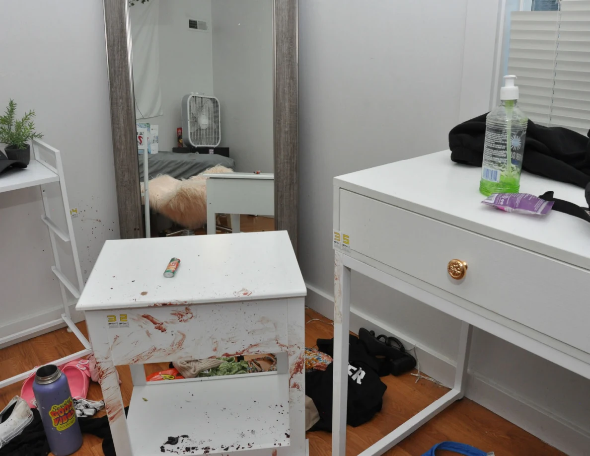 White furniture with reddish marks beside a mirror, pump bottle and toiletry packet.