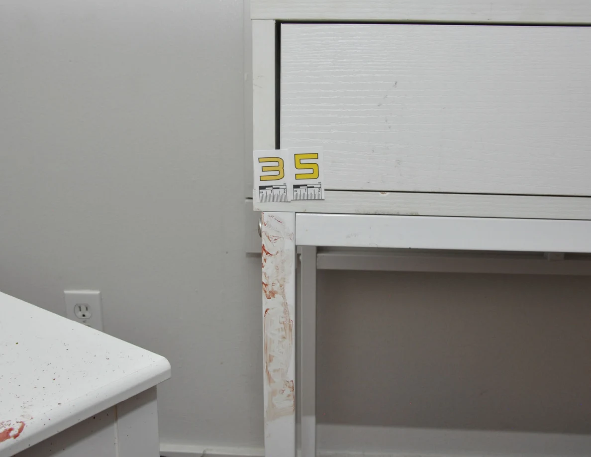 Yellow scale label 35 beside a white desk drawer and reddish leg marks.
