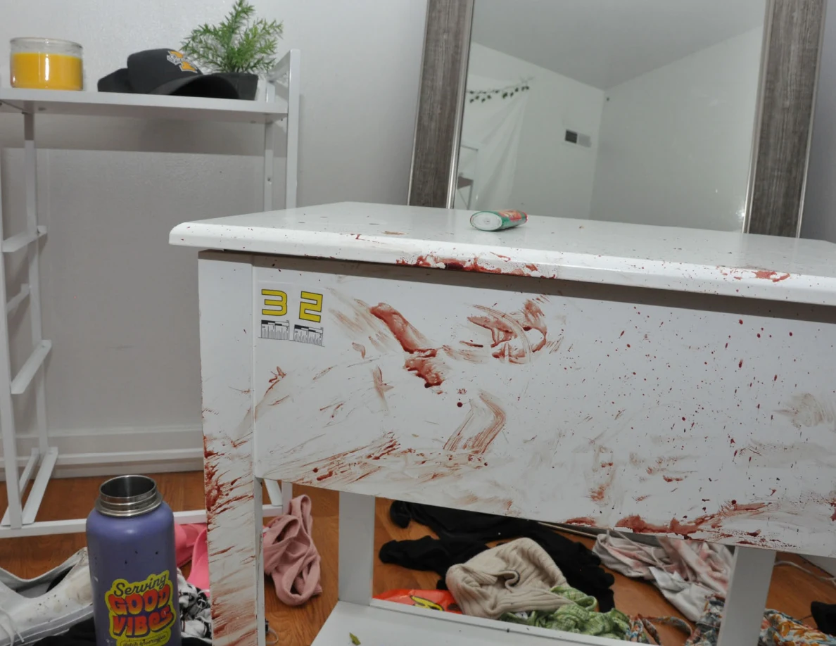 White bedside cabinet with reddish smears and scale label 32 beside a mirror.