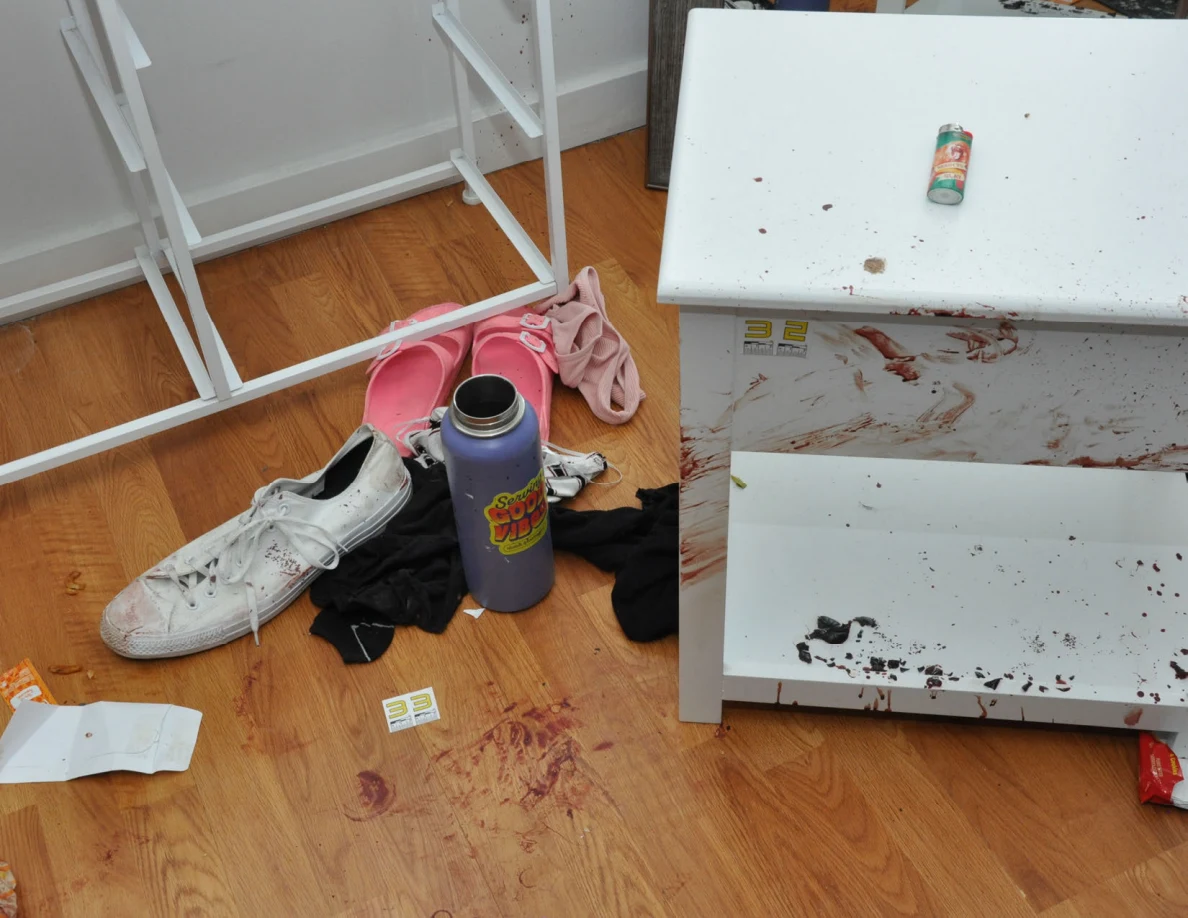 Reddish-marked cabinet beside footwear, a purple bottle and scale label 33 on the floor.