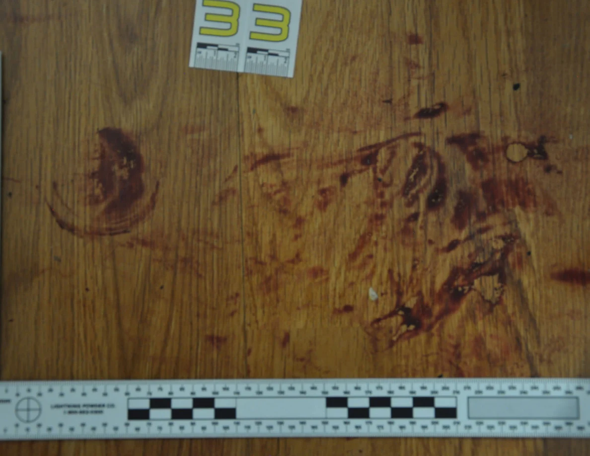 Close view of reddish floor marks above a black-and-white ruler and below label 33.