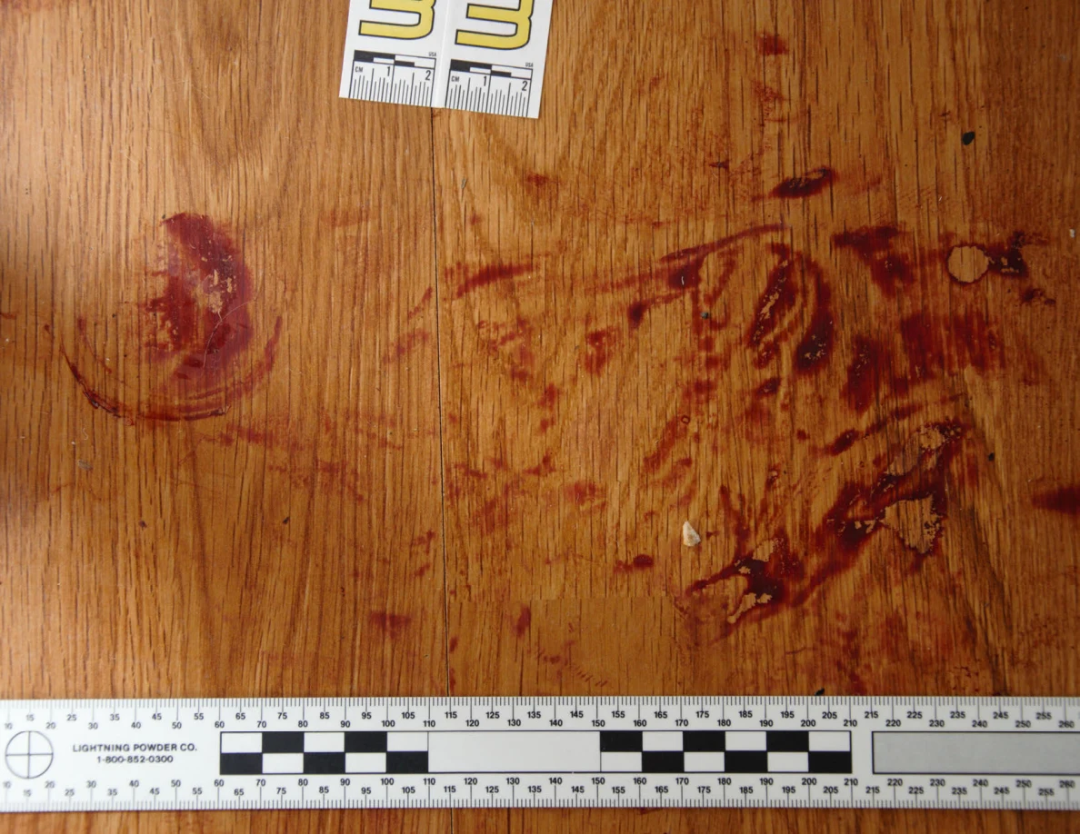 Reddish circular and smeared floor marks beside scale label 33 and a black-and-white measuring ruler.