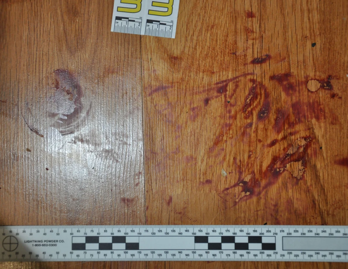 Reddish circular and smeared floor marks beside scale label 33 and a black-and-white measuring ruler.