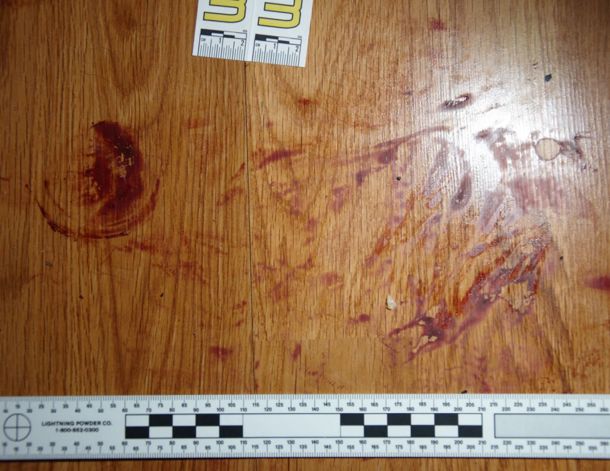 Reddish circular and smeared floor marks beside scale label 33 and a black-and-white measuring ruler.