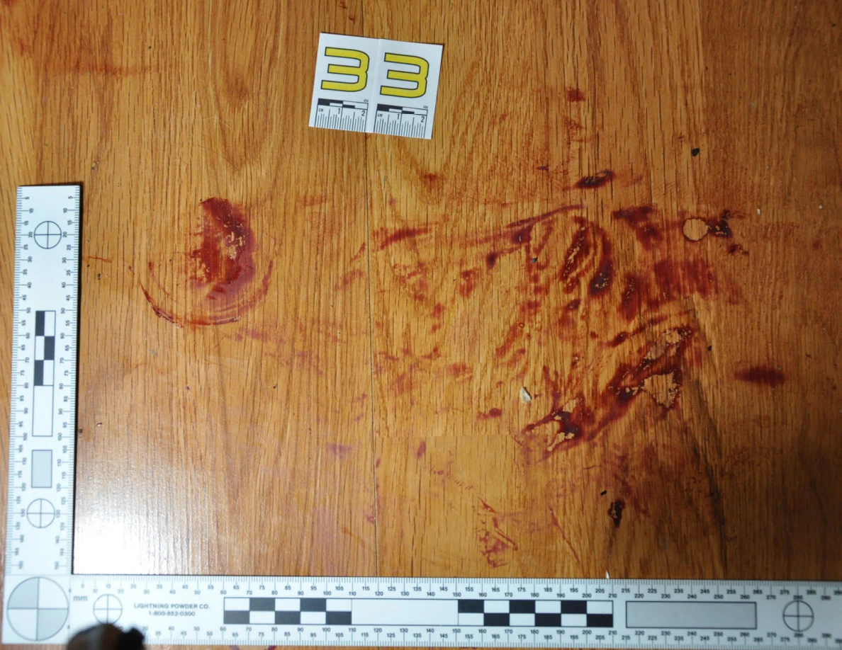 Reddish circular and smeared floor marks beside scale label 33 and measuring rulers.