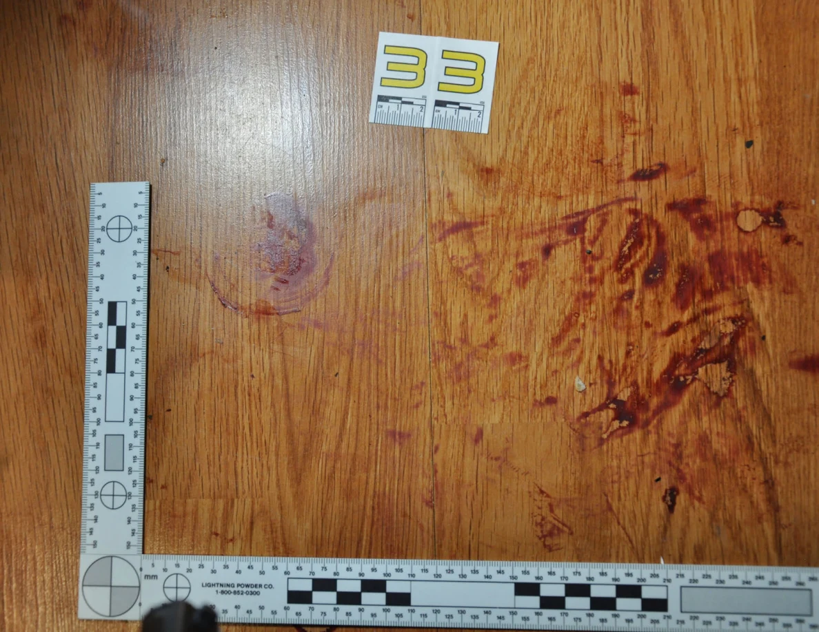 Reddish circular and smeared floor marks beside scale label 33 and measuring rulers.