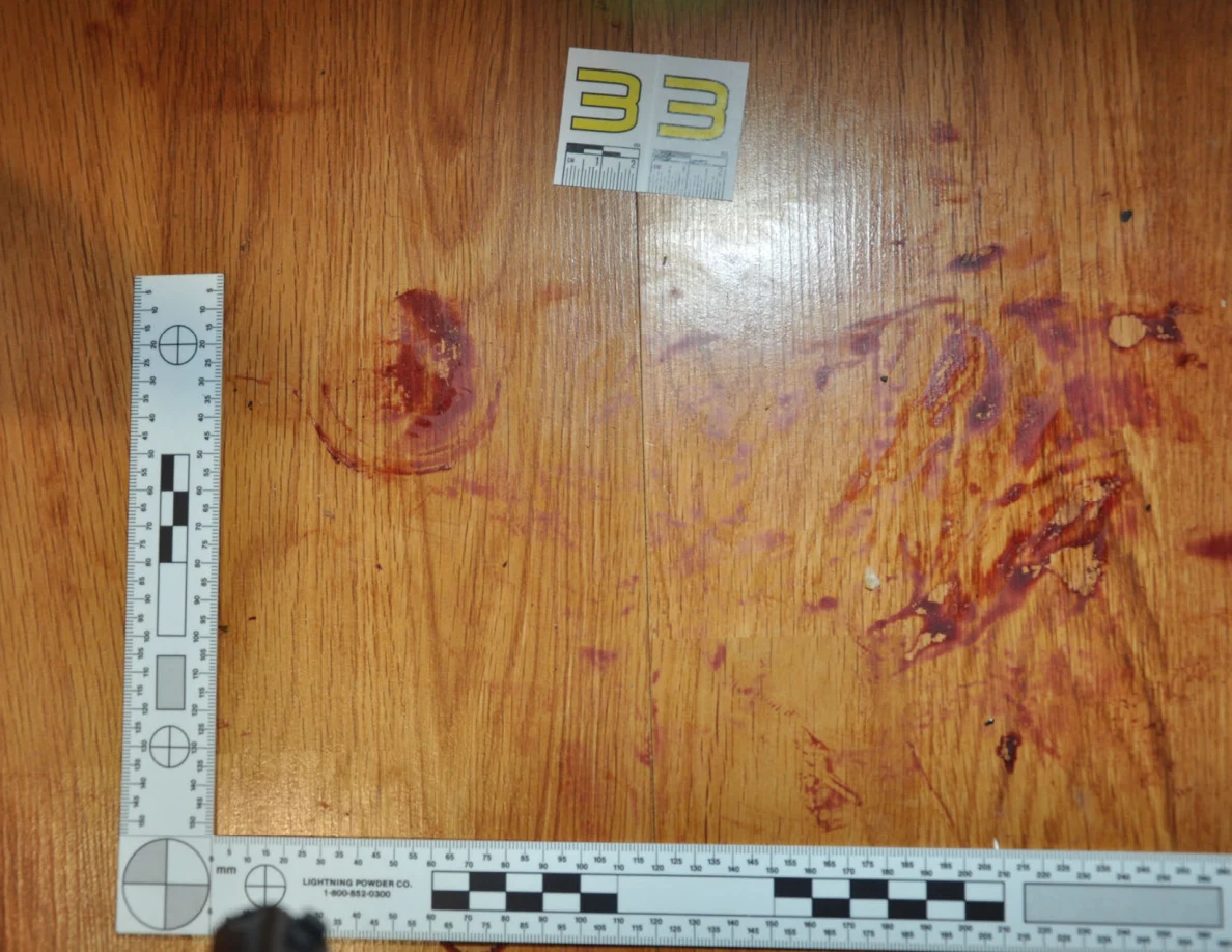 Reddish circular and smeared floor marks beside scale label 33 and measuring rulers.