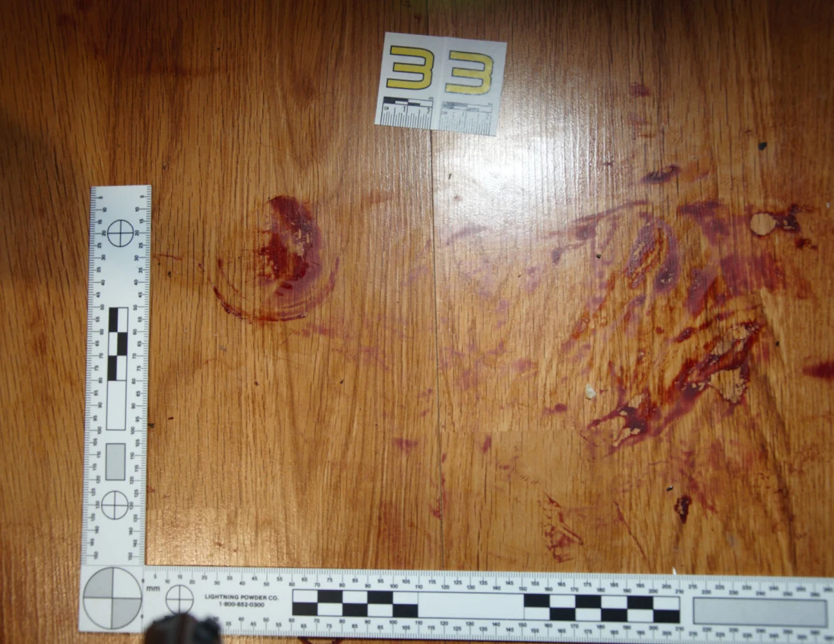 Reddish circular and smeared floor marks beside scale label 33 and measuring rulers.