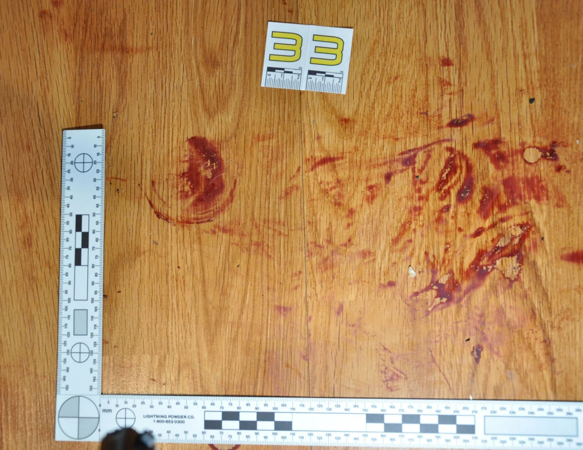 Reddish circular and smeared floor marks beside scale label 33 and measuring rulers.