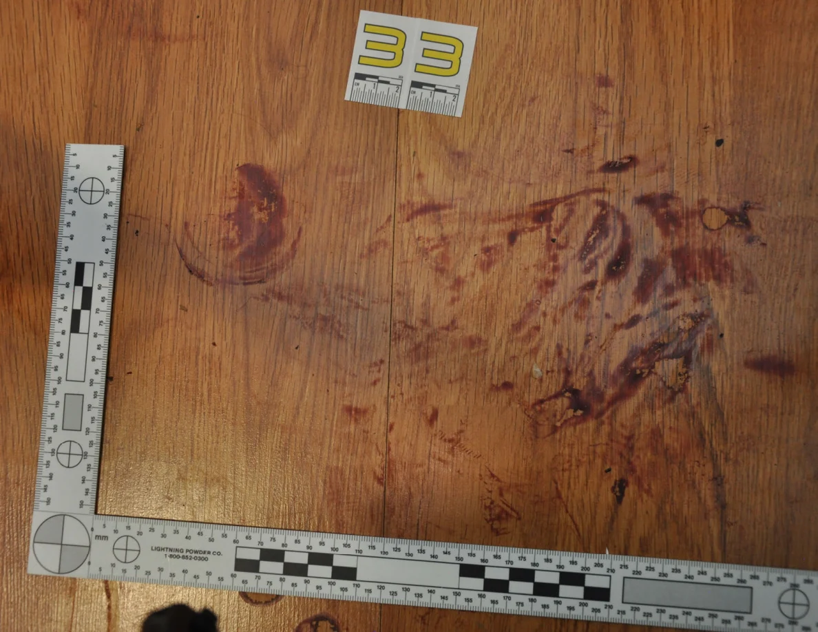 Reddish circular and smeared floor marks beside scale label 33 and measuring rulers.