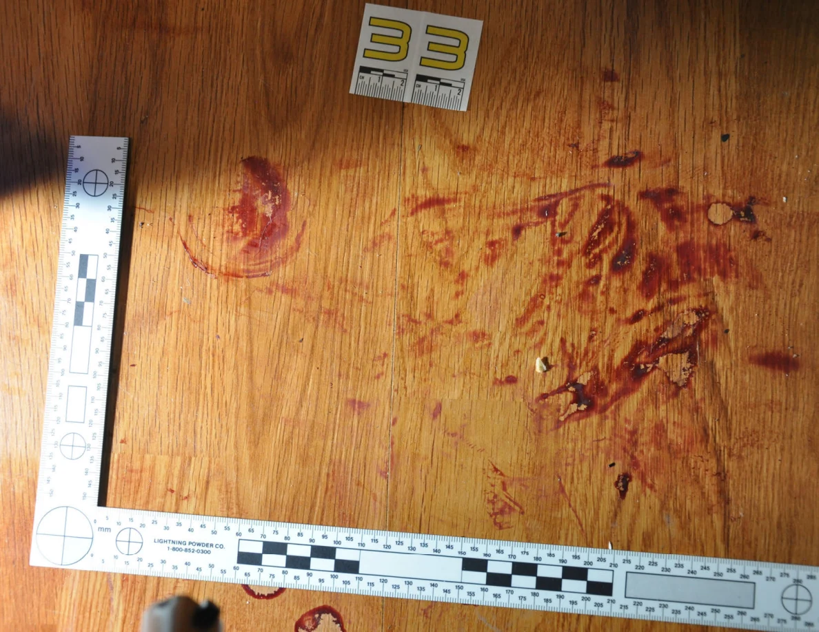Reddish circular and smeared floor marks beside scale label 33 and measuring rulers.