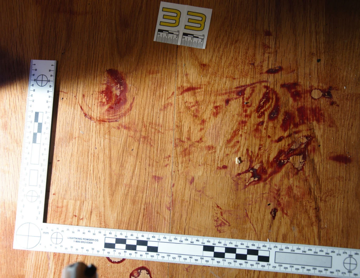 Reddish circular and smeared floor marks beside scale label 33 and measuring rulers.