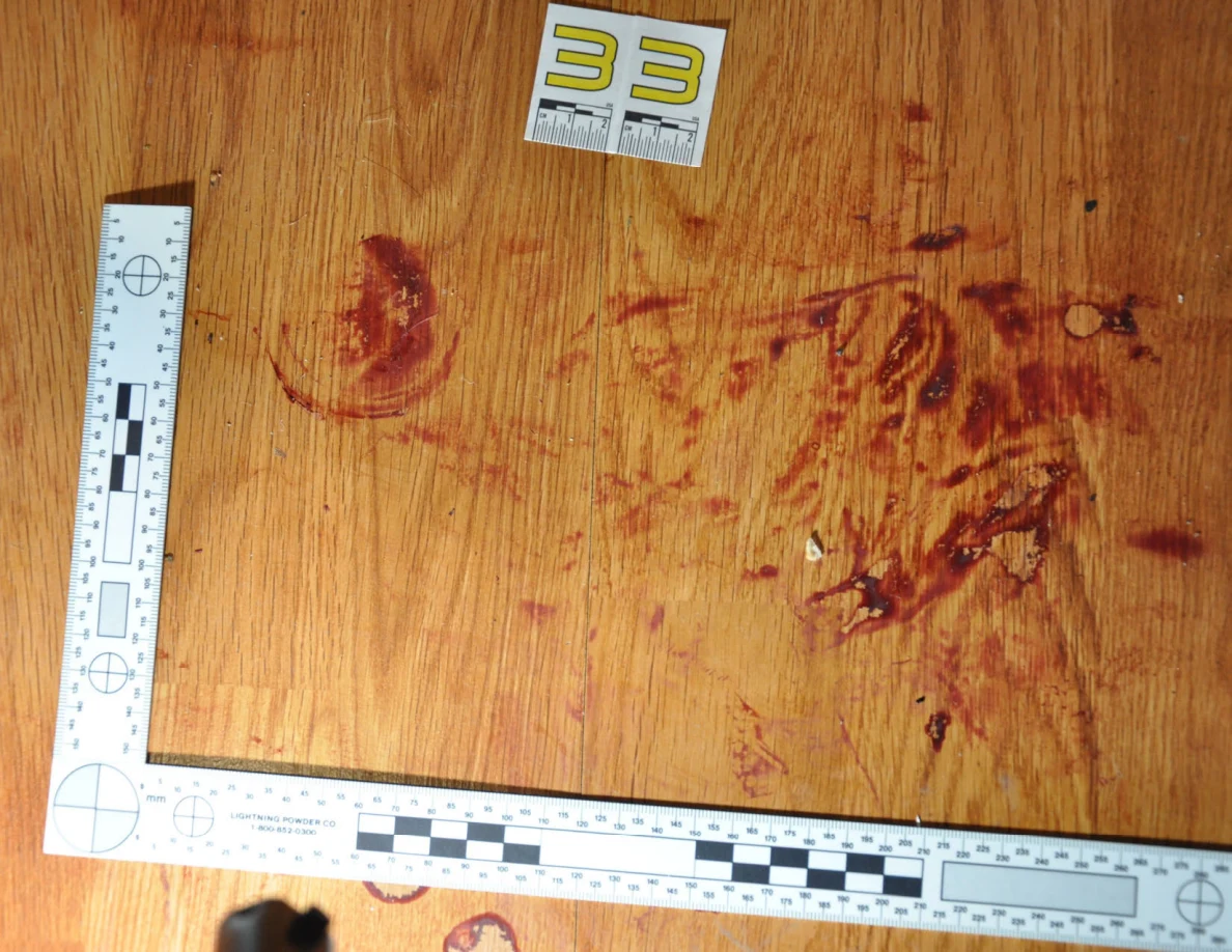 Reddish circular and smeared floor marks beside scale label 33 and measuring rulers.
