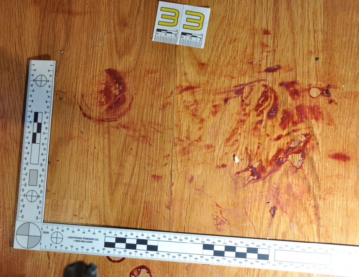 Reddish circular and smeared floor marks beside scale label 33 and measuring rulers.
