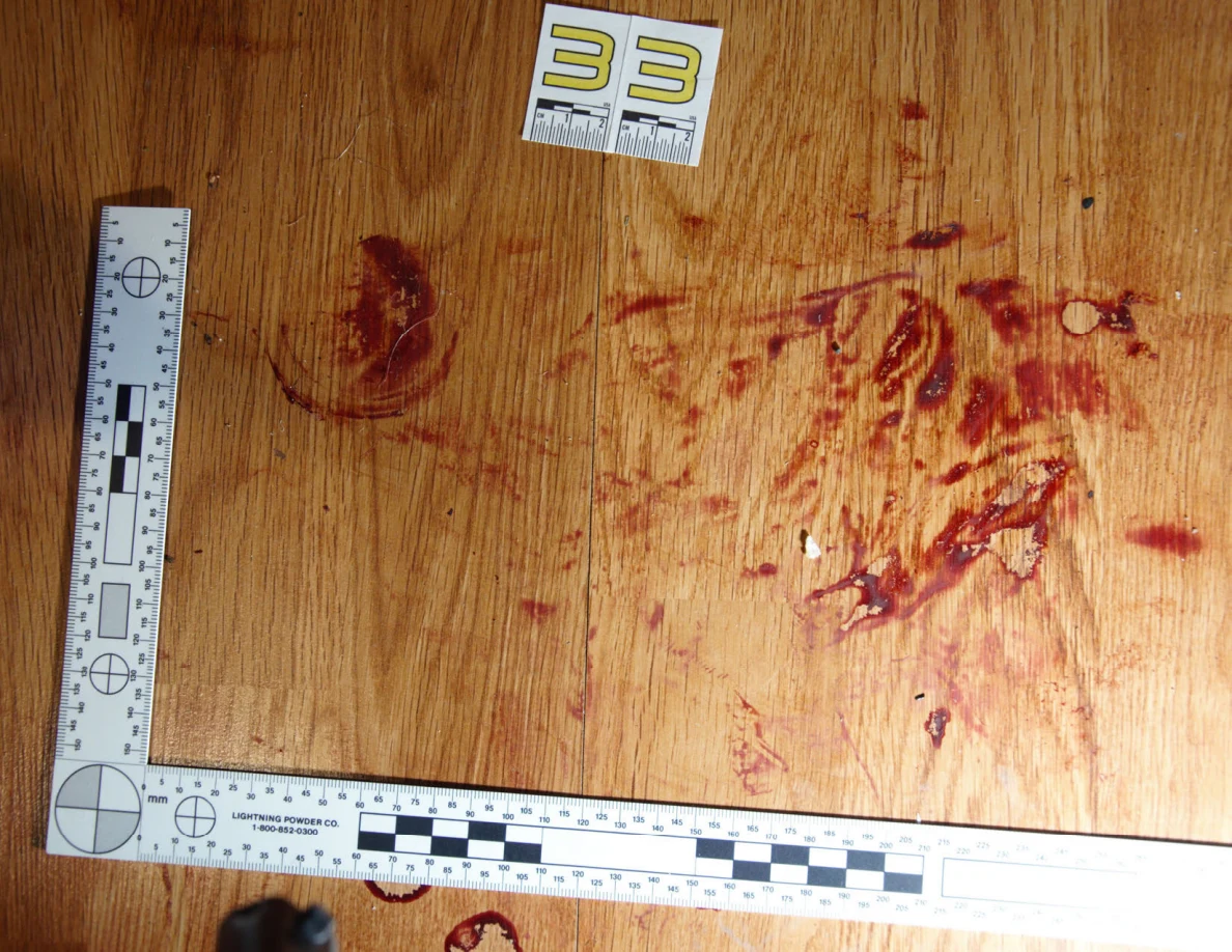 Reddish circular and smeared floor marks beside scale label 33 and measuring rulers.