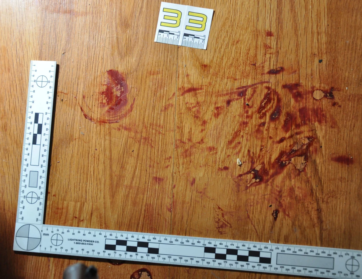 Reddish circular and smeared floor marks beside scale label 33 and measuring rulers.